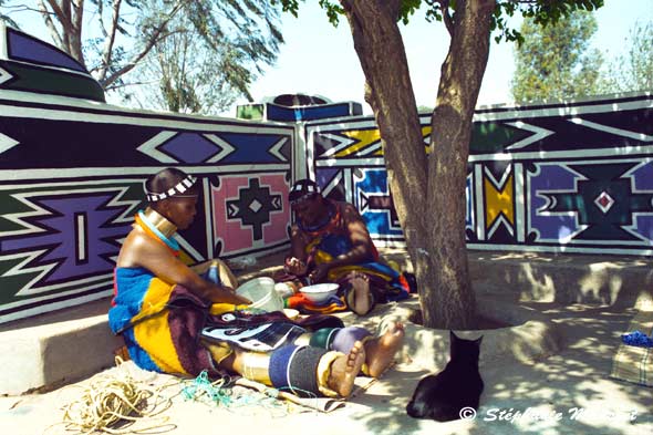 Ndebele women sitted in the shadow of a tree