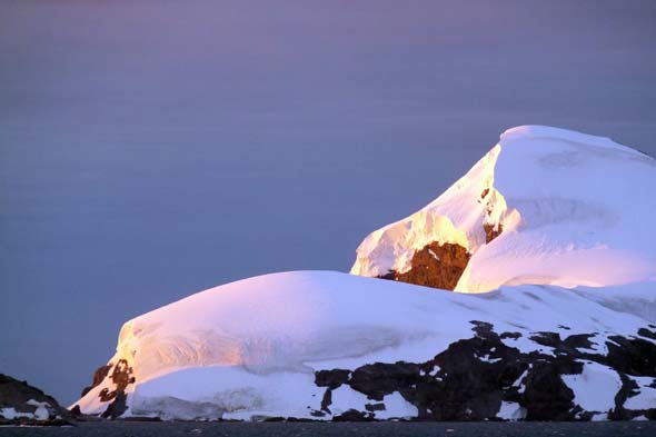 Sunset on snowy mountain in Antarctica