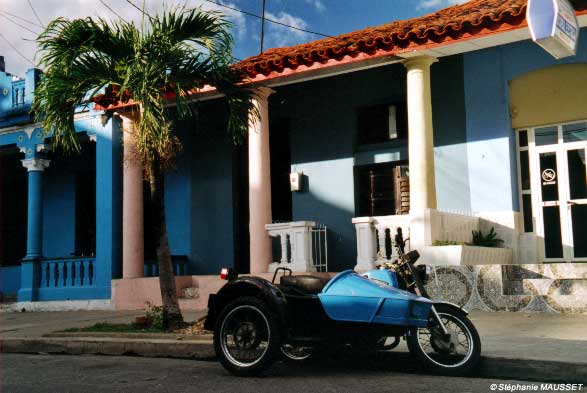 side-car garé devant façade colorée de Cuba