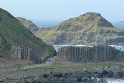 Vue sur les formations de basalte de la Chaussée des Géants avec des visiteurs au bord de la mer