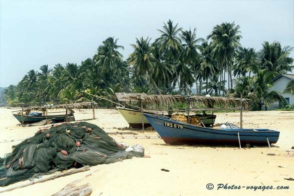 Bateaux de pêche et filets sur plage de sable