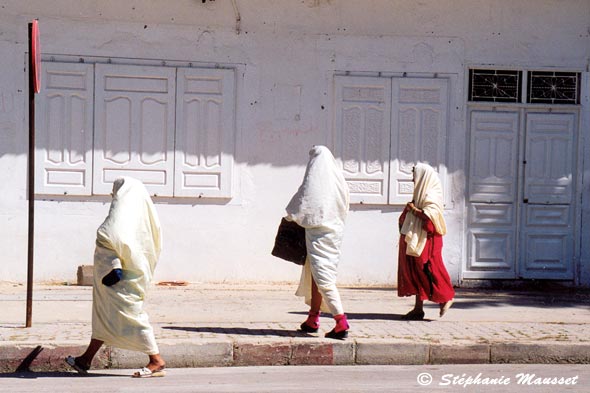 three Tunisian women veiled in white in the street