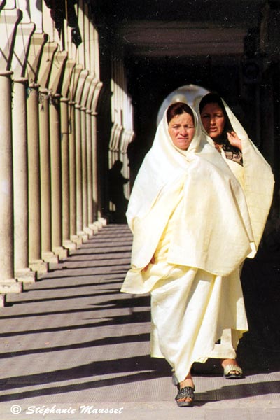 Tunisian women veiled in white and colonnades