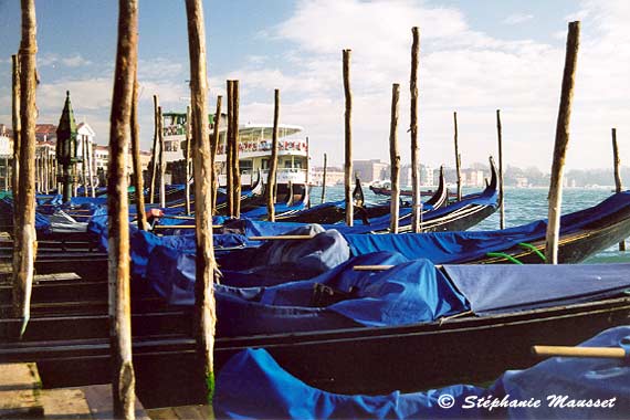 Gondolas covered with blue tarpaulins in Venice