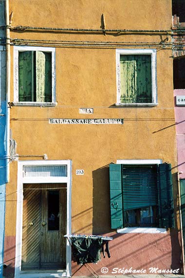 Linge qui sèche devant une maison jaune de Burano