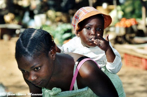 Mother or sister carrying a child on her back